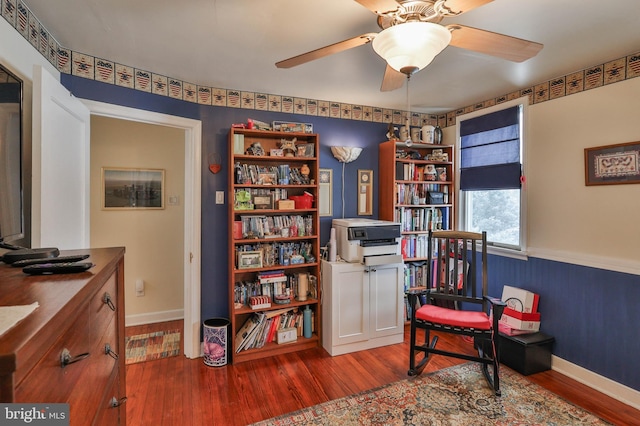 living area with wood-type flooring and ceiling fan