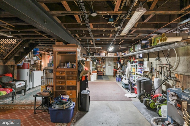 basement featuring washer and clothes dryer and electric water heater