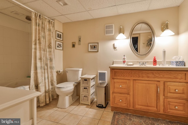 full bathroom with tile patterned flooring, vanity, toilet, a drop ceiling, and shower / bath combo with shower curtain