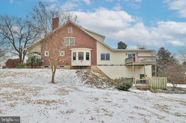 snow covered house featuring a balcony