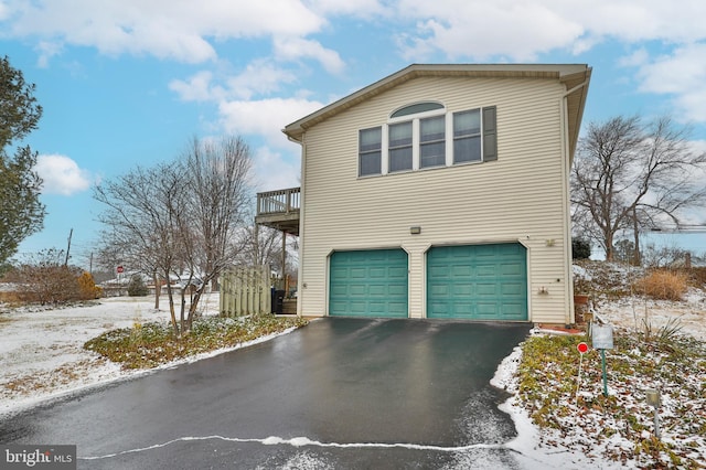 snow covered property featuring a garage