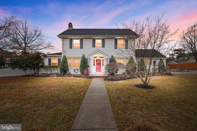 colonial-style house featuring a lawn