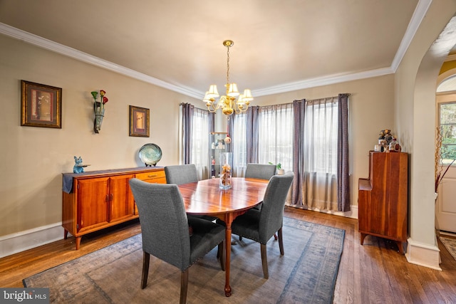 dining room with dark hardwood / wood-style flooring, a notable chandelier, and ornamental molding