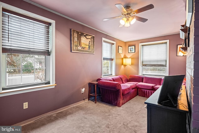 living room featuring ceiling fan, ornamental molding, a fireplace, and carpet floors