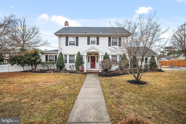 colonial inspired home with a front lawn