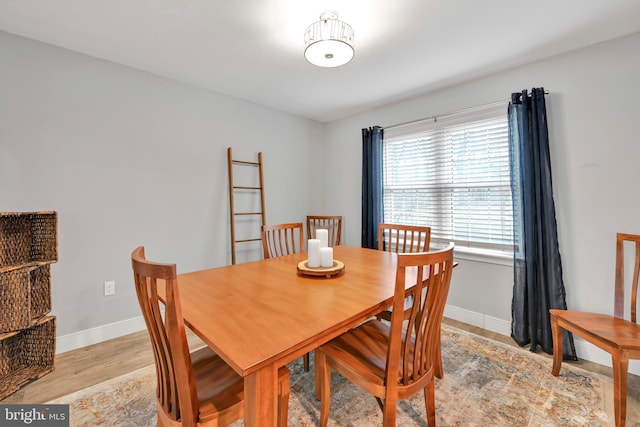 dining area with light wood-style flooring and baseboards