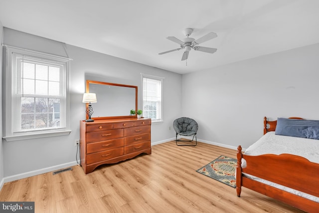 bedroom with light wood-type flooring, baseboards, visible vents, and a ceiling fan