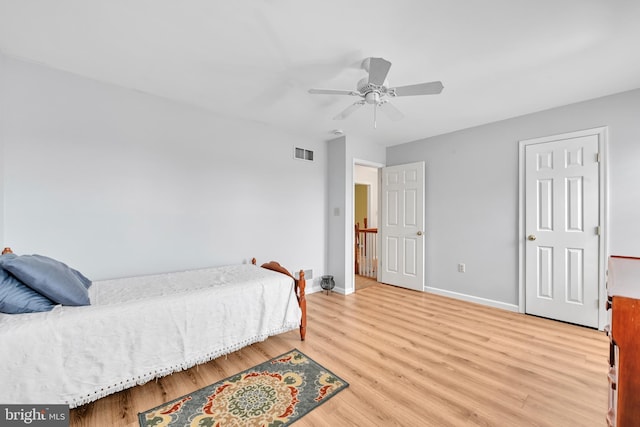 bedroom with ceiling fan, light wood finished floors, visible vents, and baseboards