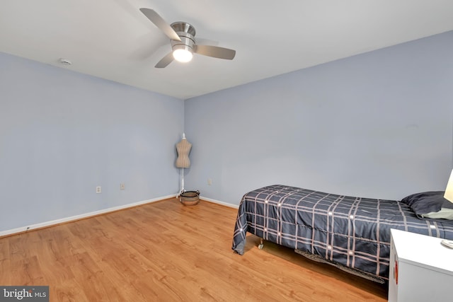 bedroom featuring ceiling fan, baseboards, and wood finished floors