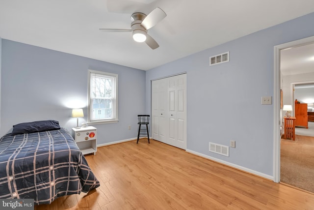 bedroom featuring baseboards, visible vents, and light wood finished floors