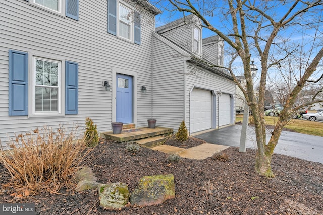 property entrance featuring aphalt driveway and a garage