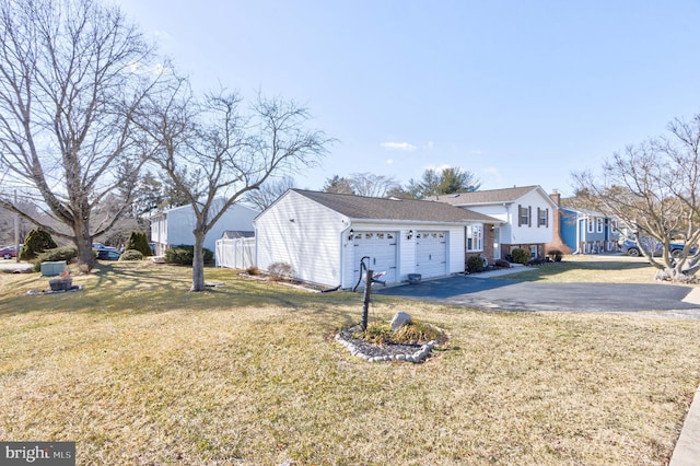 view of home's exterior featuring a garage, a lawn, driveway, and fence