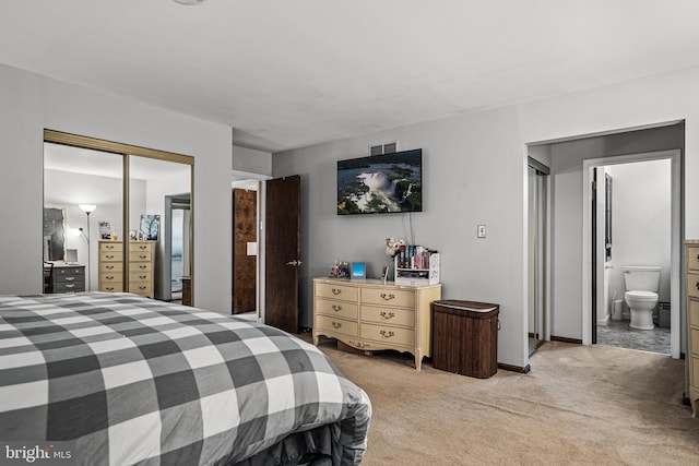 bedroom with light colored carpet, ensuite bath, and a closet