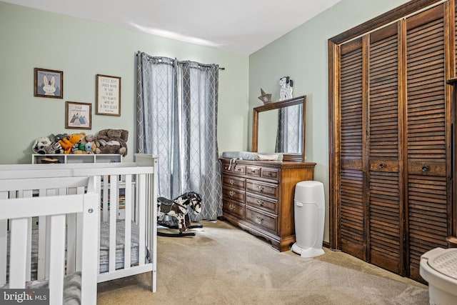 carpeted bedroom with a nursery area and a closet