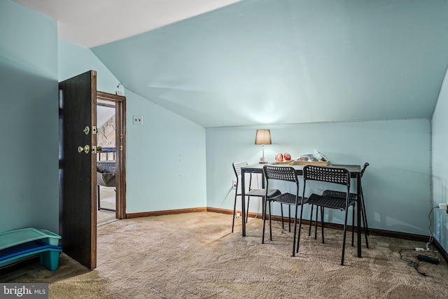 carpeted dining room featuring lofted ceiling