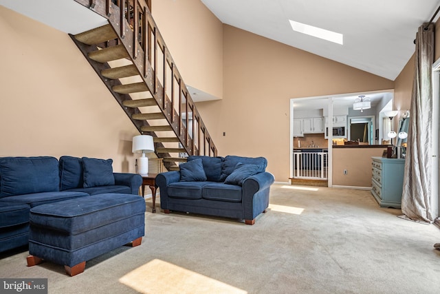 living room with light carpet, a skylight, and high vaulted ceiling