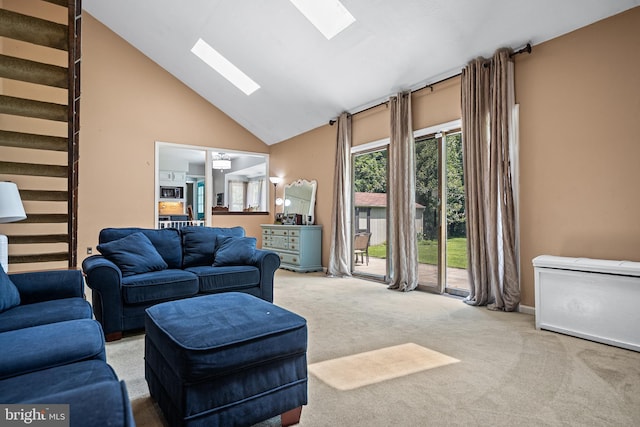 carpeted living room featuring a skylight and high vaulted ceiling