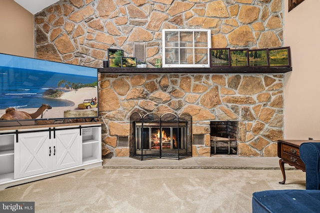 living room featuring carpet flooring and a stone fireplace