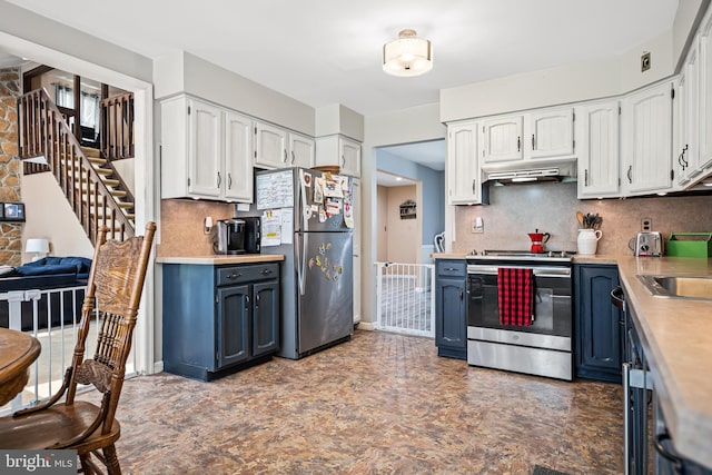 kitchen with stainless steel appliances, white cabinetry, blue cabinets, and backsplash