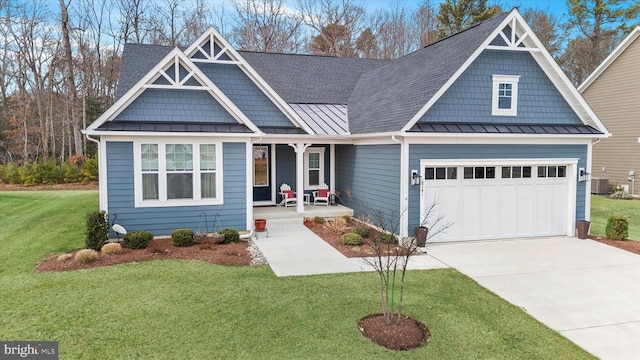 craftsman inspired home featuring a garage, covered porch, a front yard, and central air condition unit