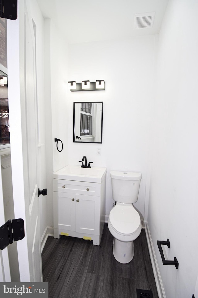 bathroom featuring vanity, hardwood / wood-style flooring, and toilet