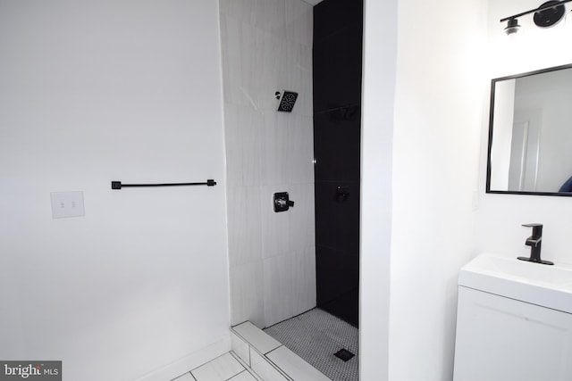 bathroom with tile patterned flooring, vanity, and tiled shower