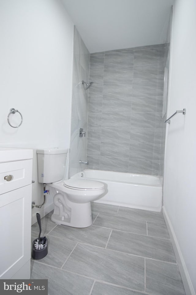 full bathroom featuring tiled shower / bath, vanity, and toilet