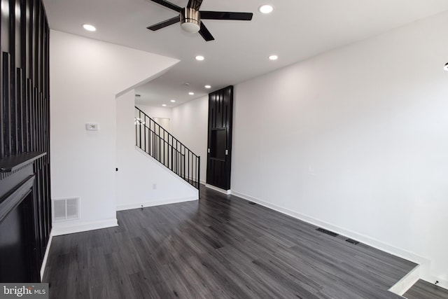 unfurnished living room featuring ceiling fan and dark hardwood / wood-style floors