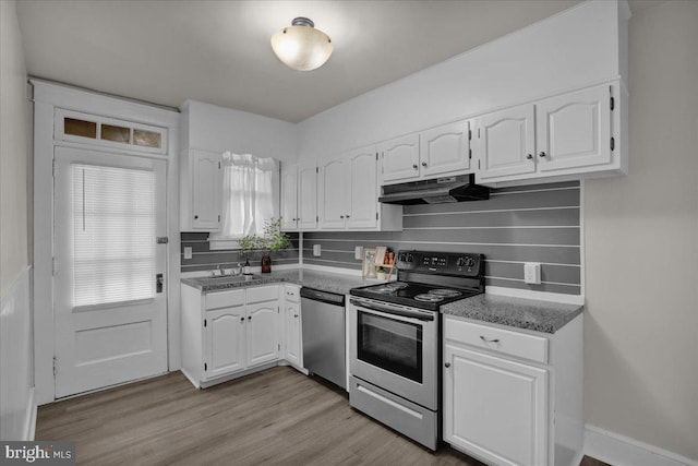 kitchen with white cabinetry, decorative backsplash, light hardwood / wood-style floors, and appliances with stainless steel finishes