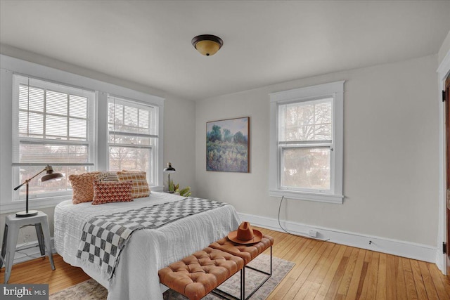 bedroom with wood-type flooring and multiple windows