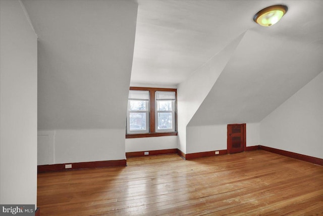 bonus room with vaulted ceiling and light hardwood / wood-style floors