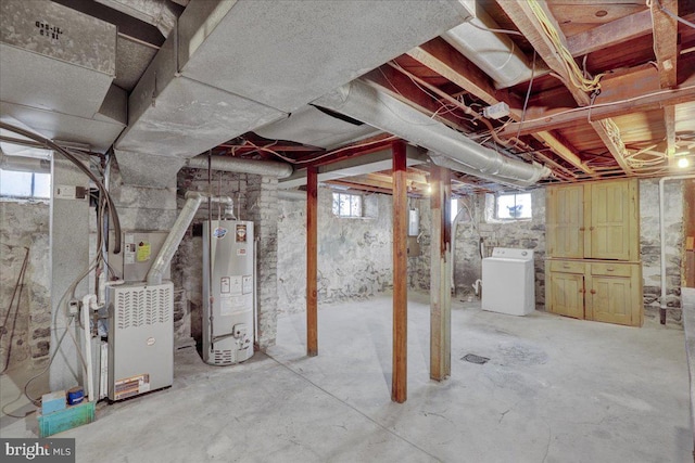 basement featuring heating unit, washer / dryer, and water heater