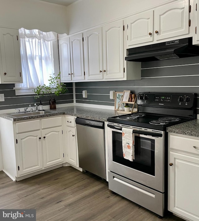 kitchen with stainless steel appliances, white cabinetry, dark hardwood / wood-style floors, and sink