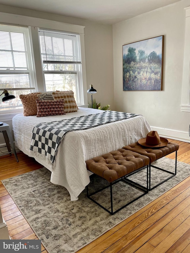 bedroom with multiple windows and wood-type flooring