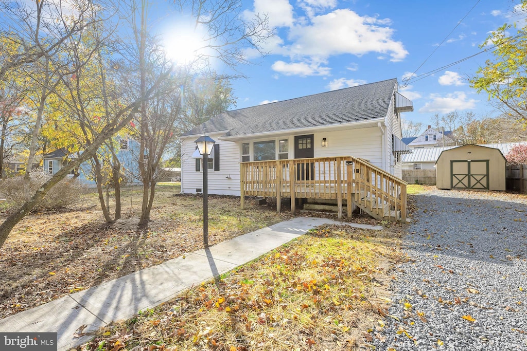 view of front of home with a deck and a storage unit