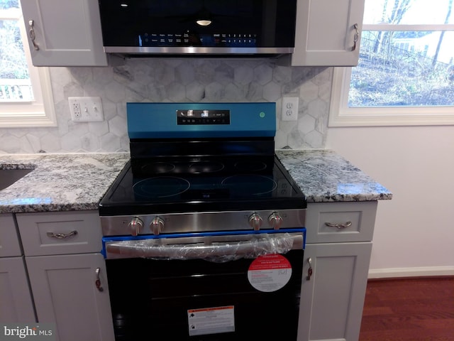 kitchen featuring white cabinetry, appliances with stainless steel finishes, and light stone countertops