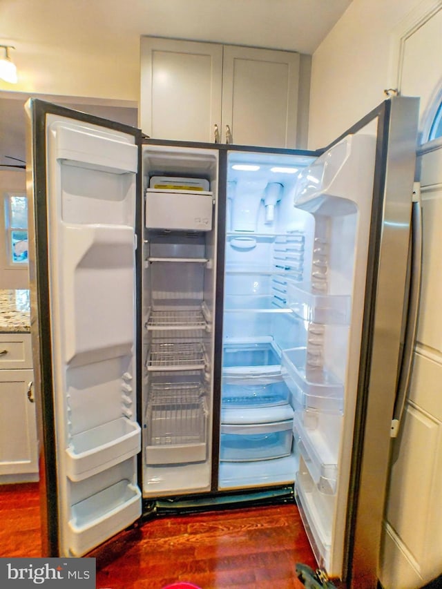 room details featuring white cabinetry, dark wood-type flooring, and refrigerator