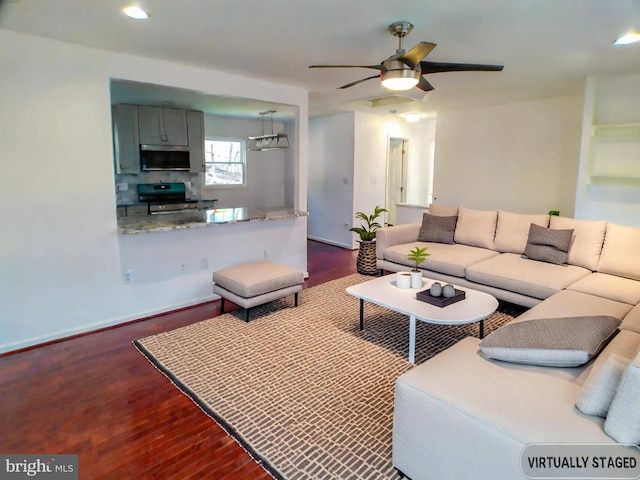 living room with dark hardwood / wood-style flooring and ceiling fan