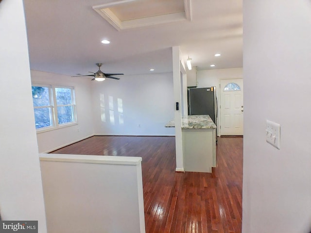 kitchen with dark hardwood / wood-style flooring, white cabinetry, stainless steel refrigerator, and ceiling fan