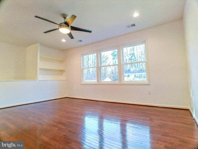 empty room with dark wood-type flooring and ceiling fan