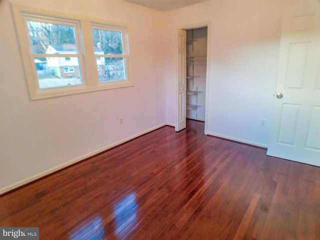 unfurnished bedroom featuring dark wood-type flooring and a closet