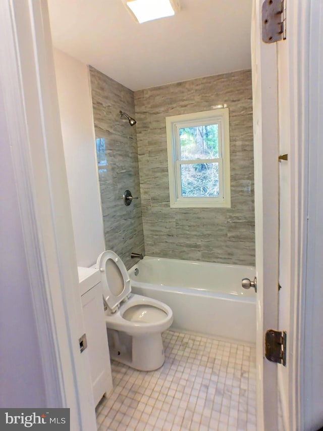 full bathroom with tiled shower / bath, vanity, toilet, and tile patterned floors