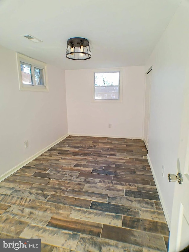 spare room featuring dark wood-type flooring and a wealth of natural light