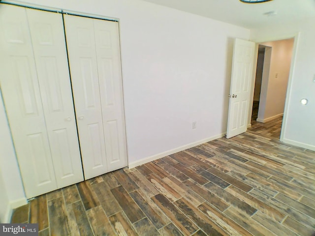 unfurnished bedroom featuring dark wood-type flooring and a closet