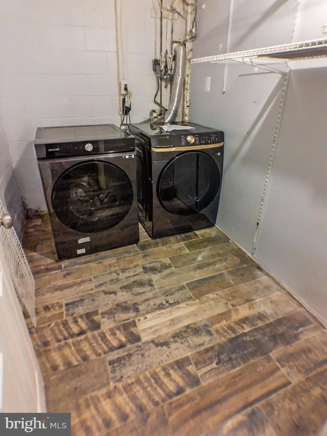 clothes washing area with independent washer and dryer and hardwood / wood-style floors