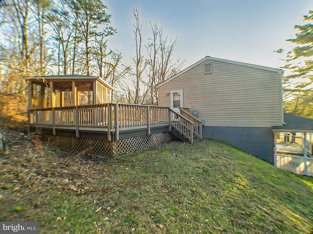 back of house with a yard, a sunroom, and a deck