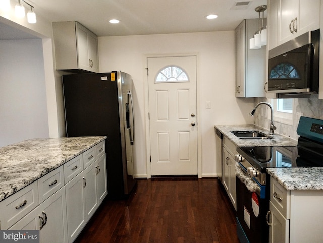 kitchen with stainless steel appliances, sink, hanging light fixtures, and white cabinets