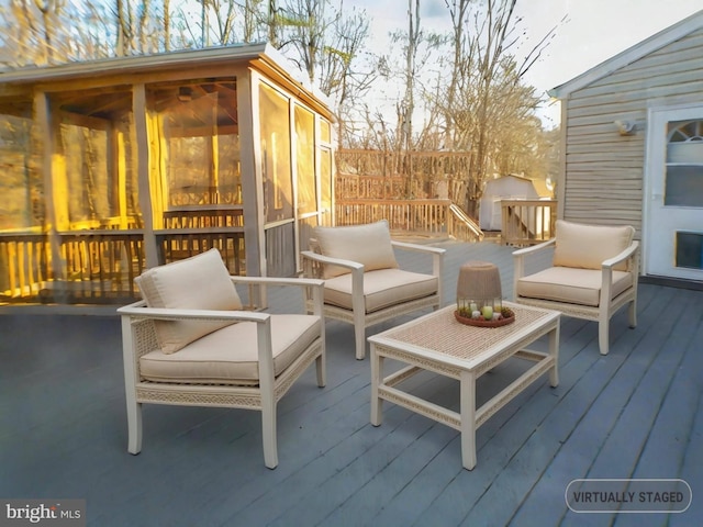 wooden deck with a sunroom and a storage unit