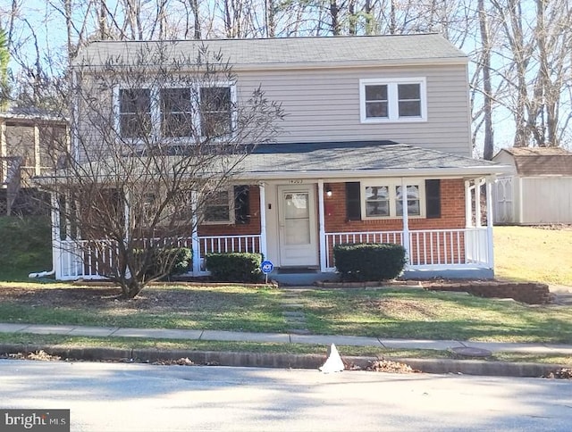 view of front facade with a porch, a shed, and a front yard