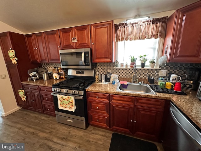 kitchen featuring appliances with stainless steel finishes, sink, dark wood-type flooring, and decorative backsplash